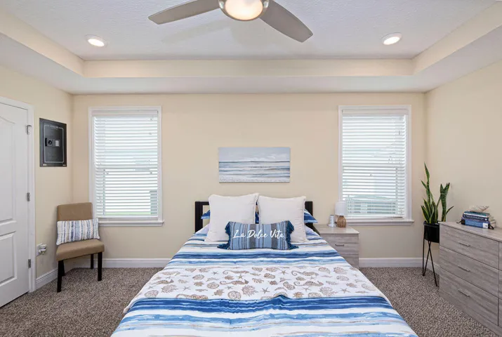 Primary bedroom with tray ceiling, recessed lighting, ceiling fan and plush carpet