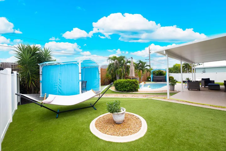 Turf backyard with hammock, gazebo and pool views