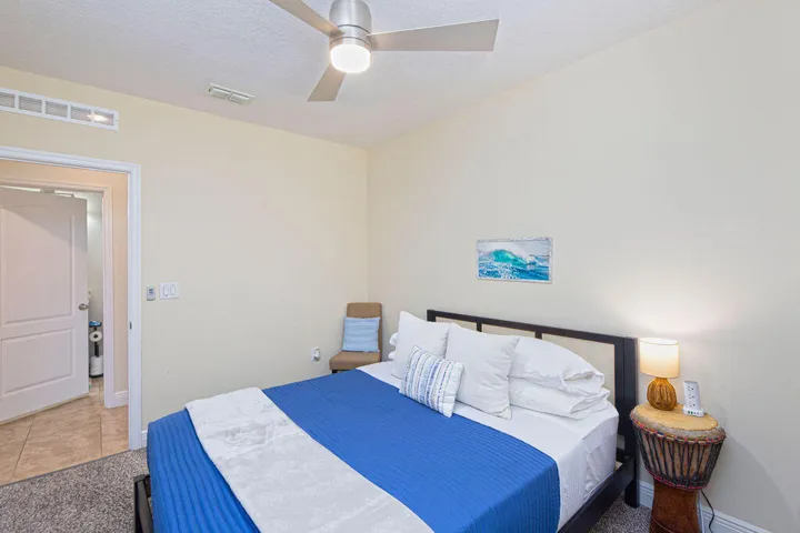 Bedroom with queen bed, ceiling fan and carpet
