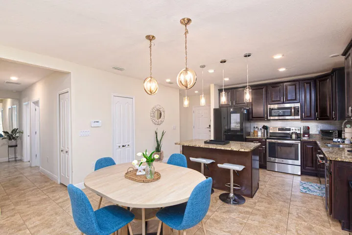 Open-concept living space featuring ceramic tile flooring, recessed lighting, and a kitchen island with seating