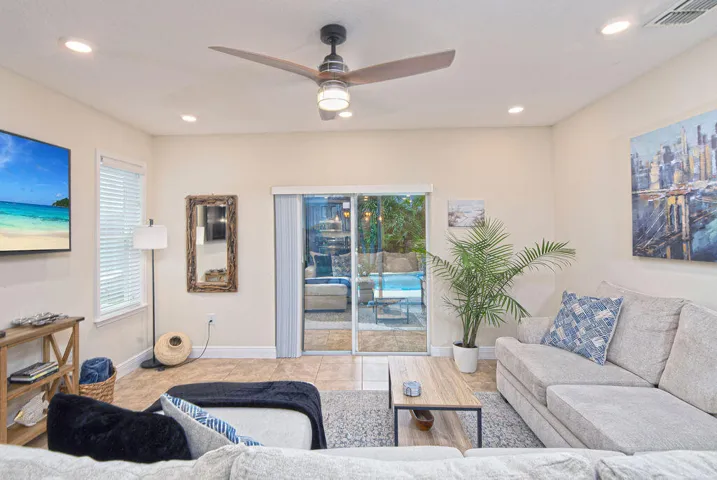 Recessed lighting, ceiling fan with integrated lighting, tile flooring, sliding glass door, and a visible pool area
