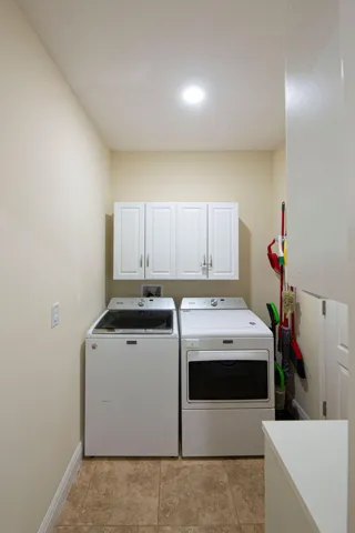Laundry room with washer, dryer and upper cabinets
