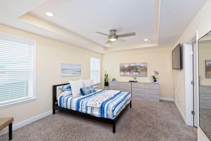 Recessed lighting, tray ceiling, ceiling fan, white window blinds, and neutral wall paint
