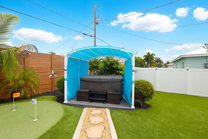 Hot tub under a covered gazebo next to the putting green