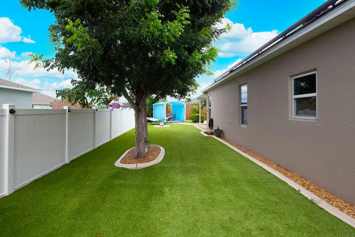 Turf side yard with shade tree and privacy fence