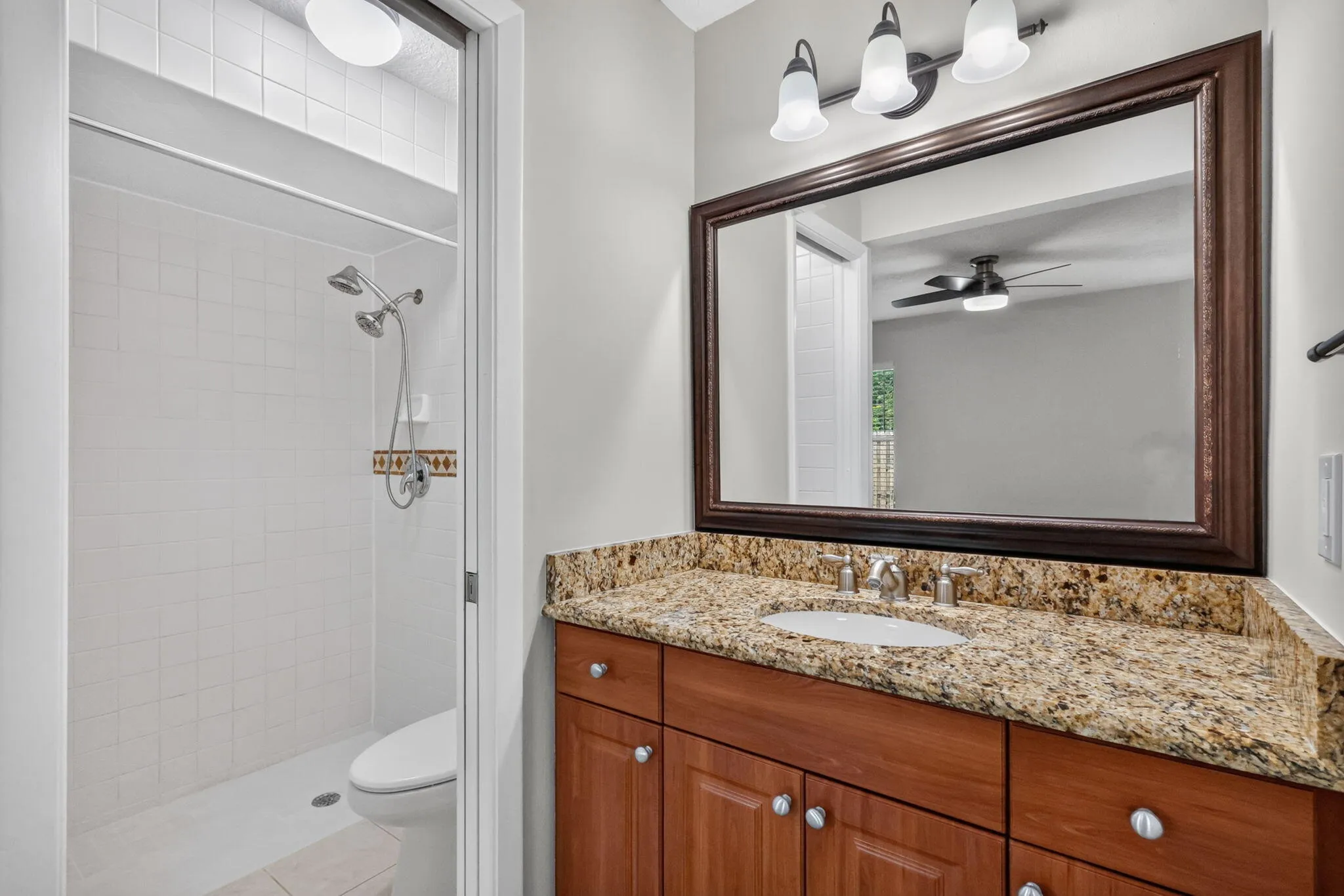 Wood-finish vanity with a stone countertop and an undermount sink