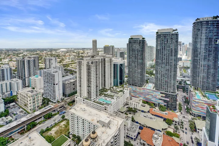 Unobstructed Expansive urban panorama featuring multiple high-rise structures and a railway line