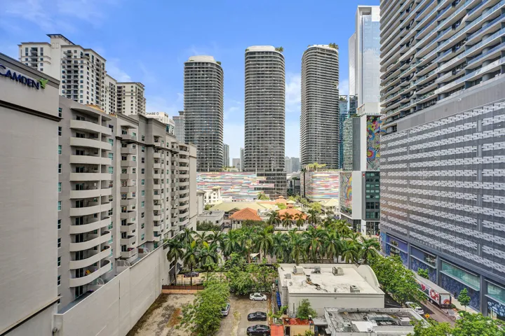 City skyline with multiple high-rise buildings and mature palm trees