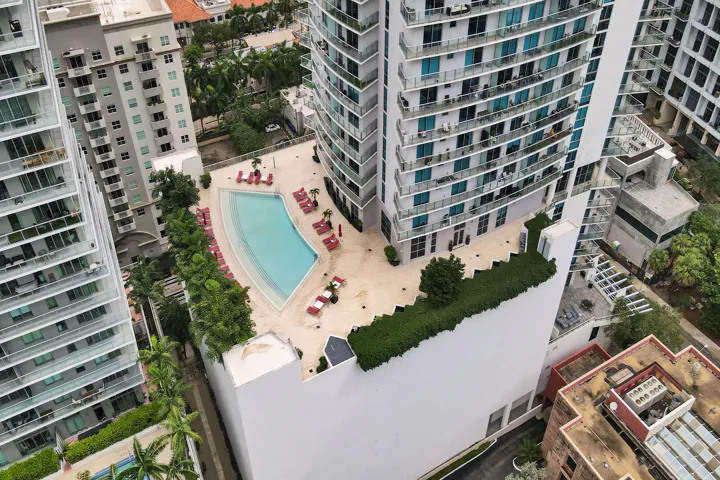 Resort-style pool with integrated steps, surrounded by a paved patio area