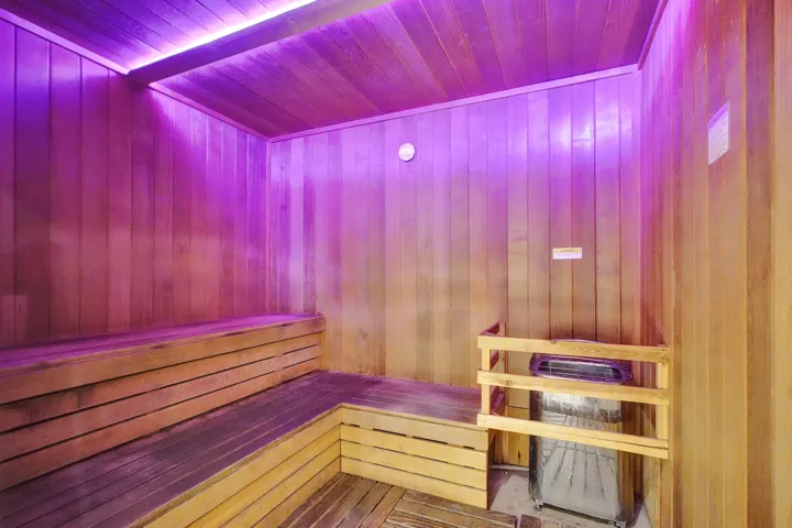 Wood-paneled interior featuring built-in wood benches and a floor-mounted heating unit