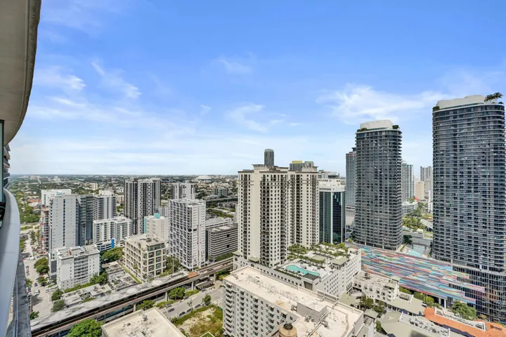 City skyline with diverse architectural styles, elevated rail infrastructure, and multiple high-rise structures