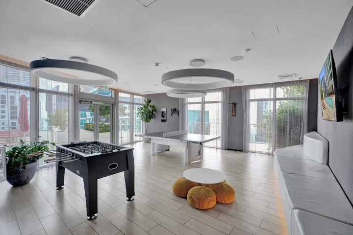 Recessed lighting, wood-finish flooring, full-height windows, and contemporary circular light fixtures