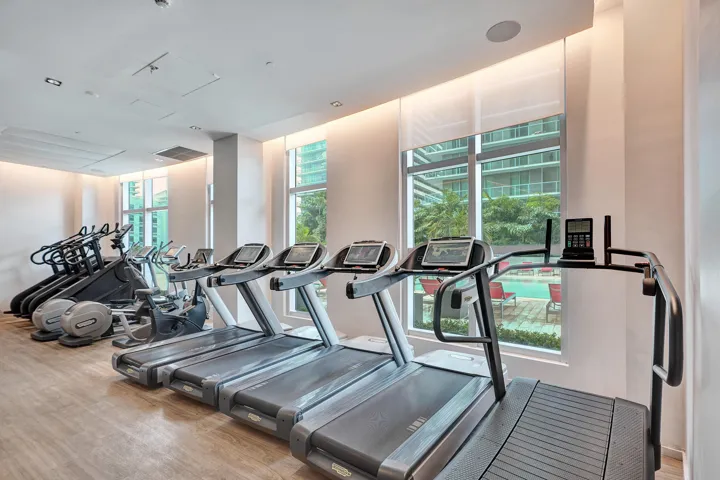 Fitness center featuring multiple treadmills, elliptical machines, and stationary bikes