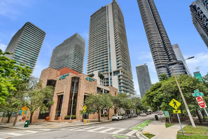 Urban setting featuring multiple high-rise buildings, a street with street parking, and a dedicated bike lane