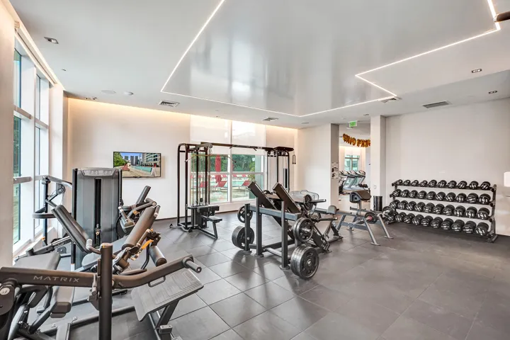 Gym space featuring floor-to-ceiling windows, recessed lighting, and a full complement of exercise equipment