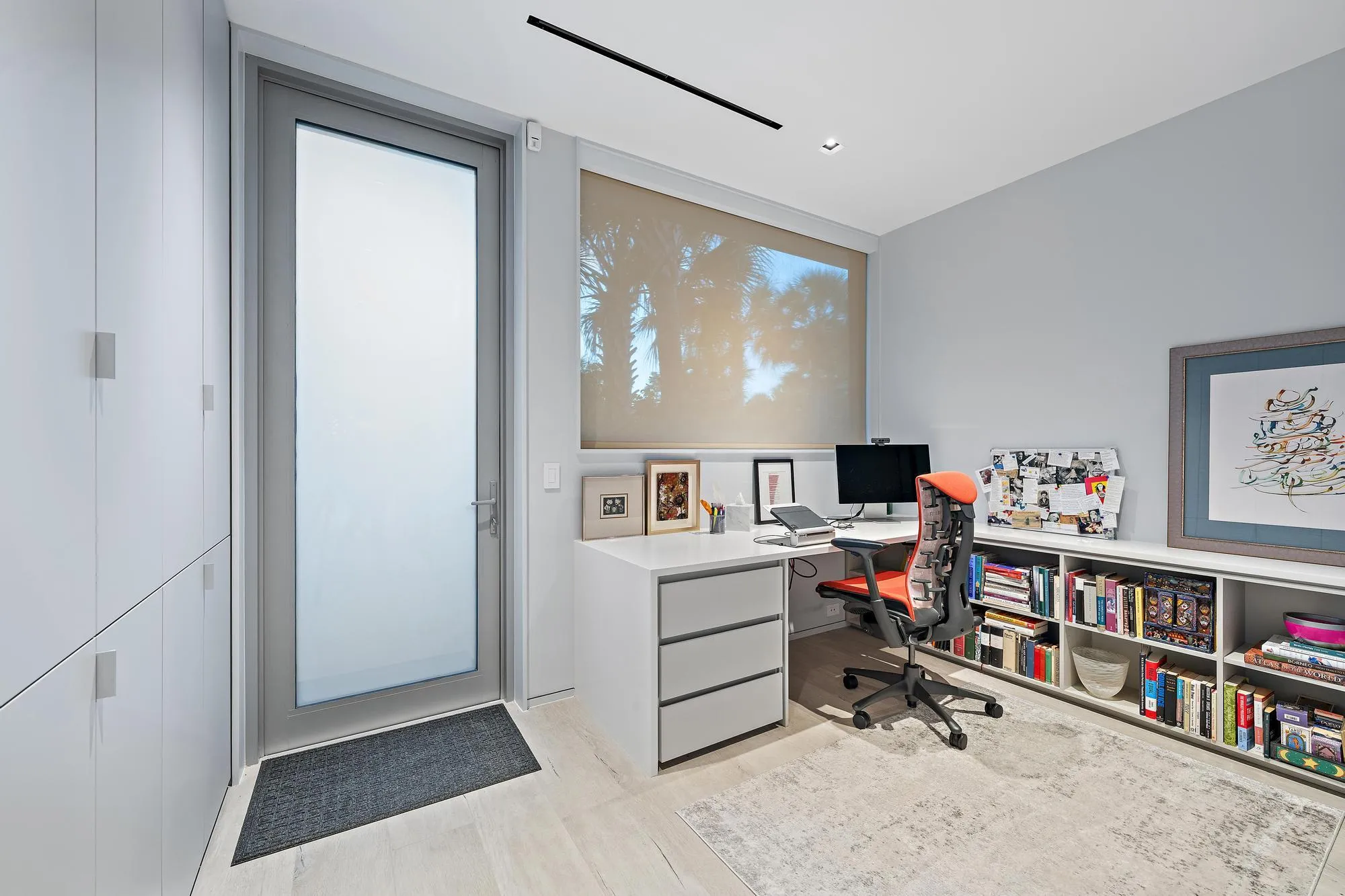 Built-in desk with three drawers, integrated shelving, and wood-finish flooring