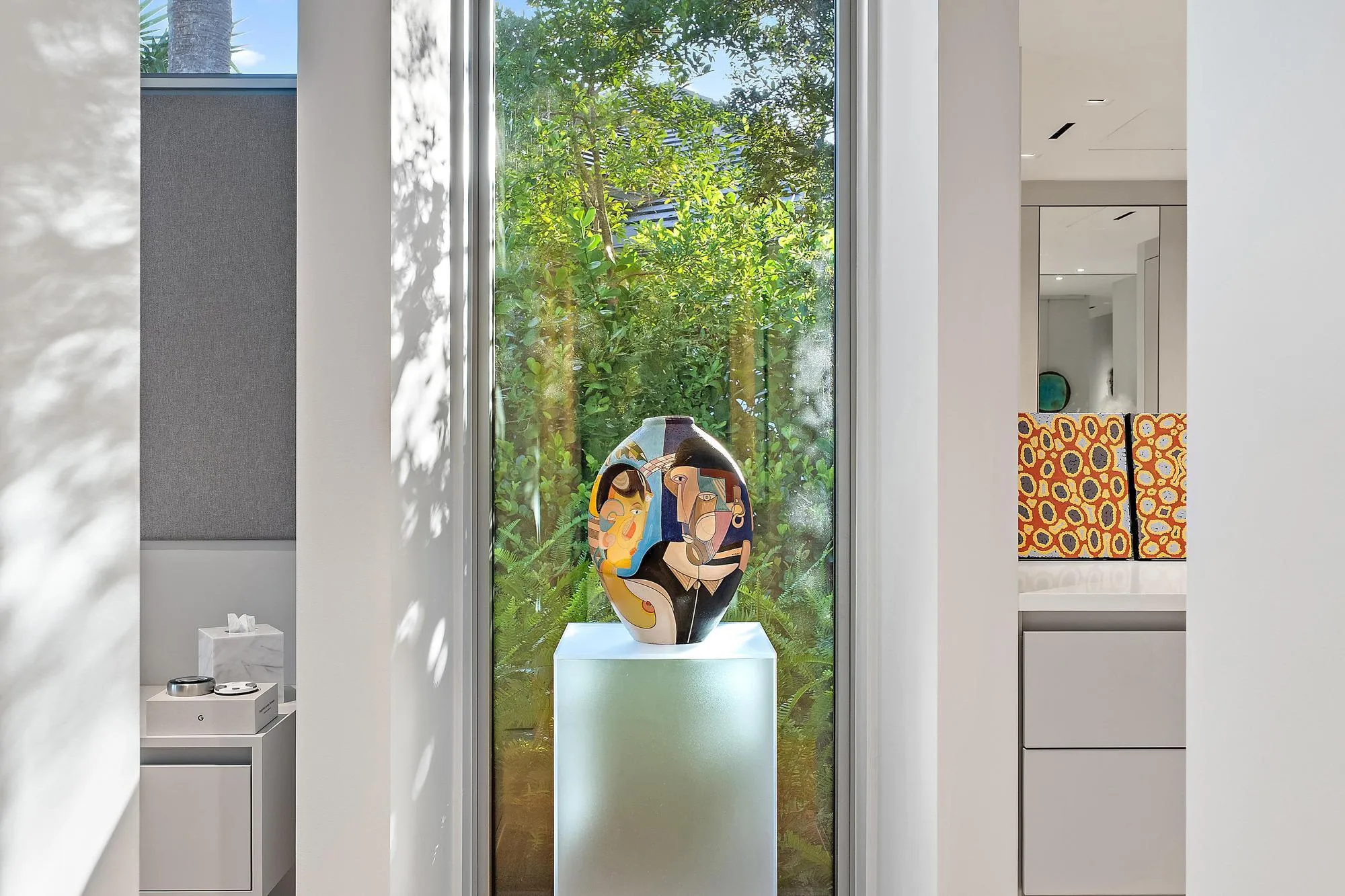 Floor-to-ceiling window with abundant natural light, showcasing built-in cabinetry, an integrated mirror, and recessed lighting