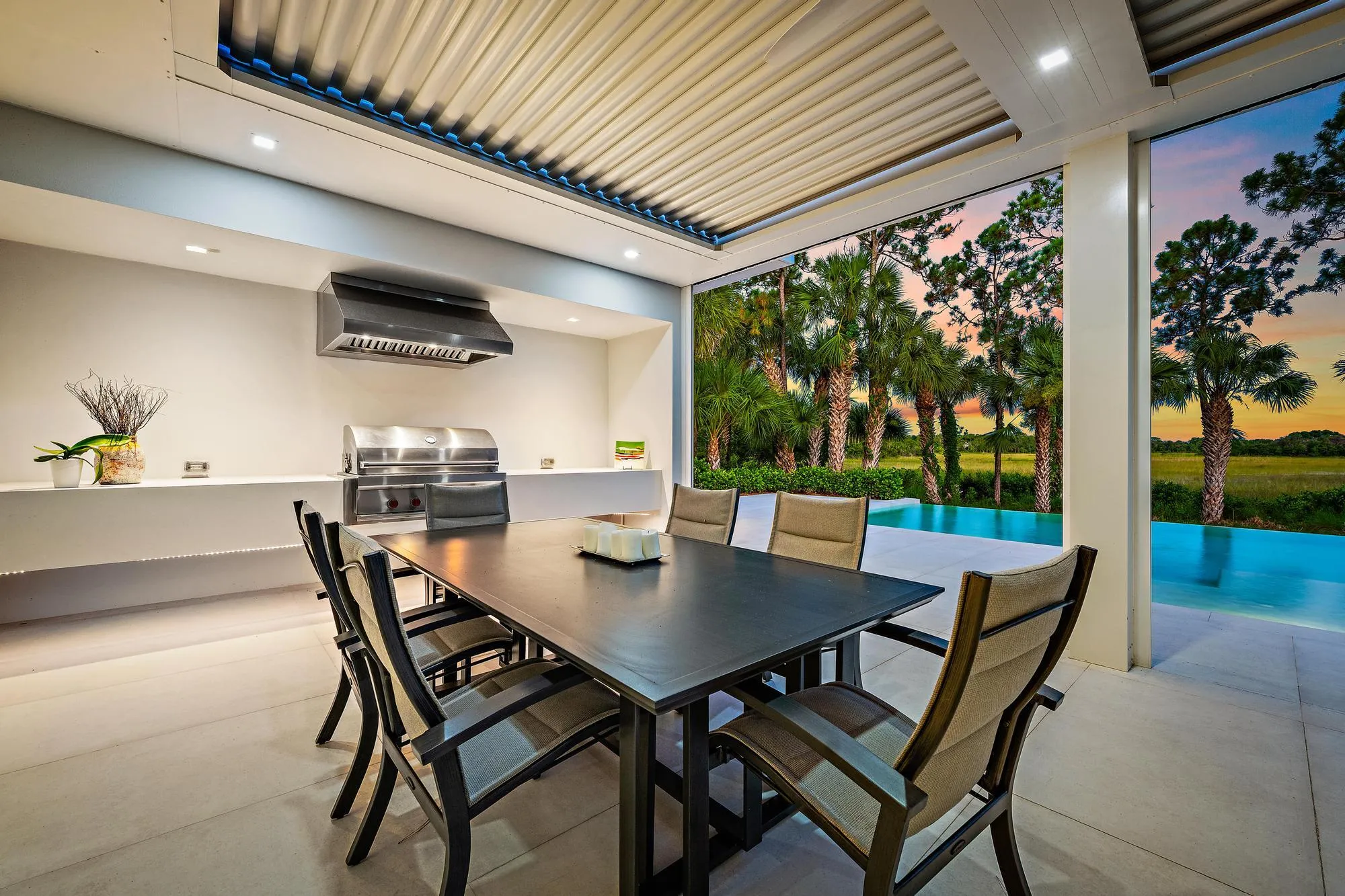 Outdoor living space featuring a built-in grill, range hood, and a flat-panel ceiling