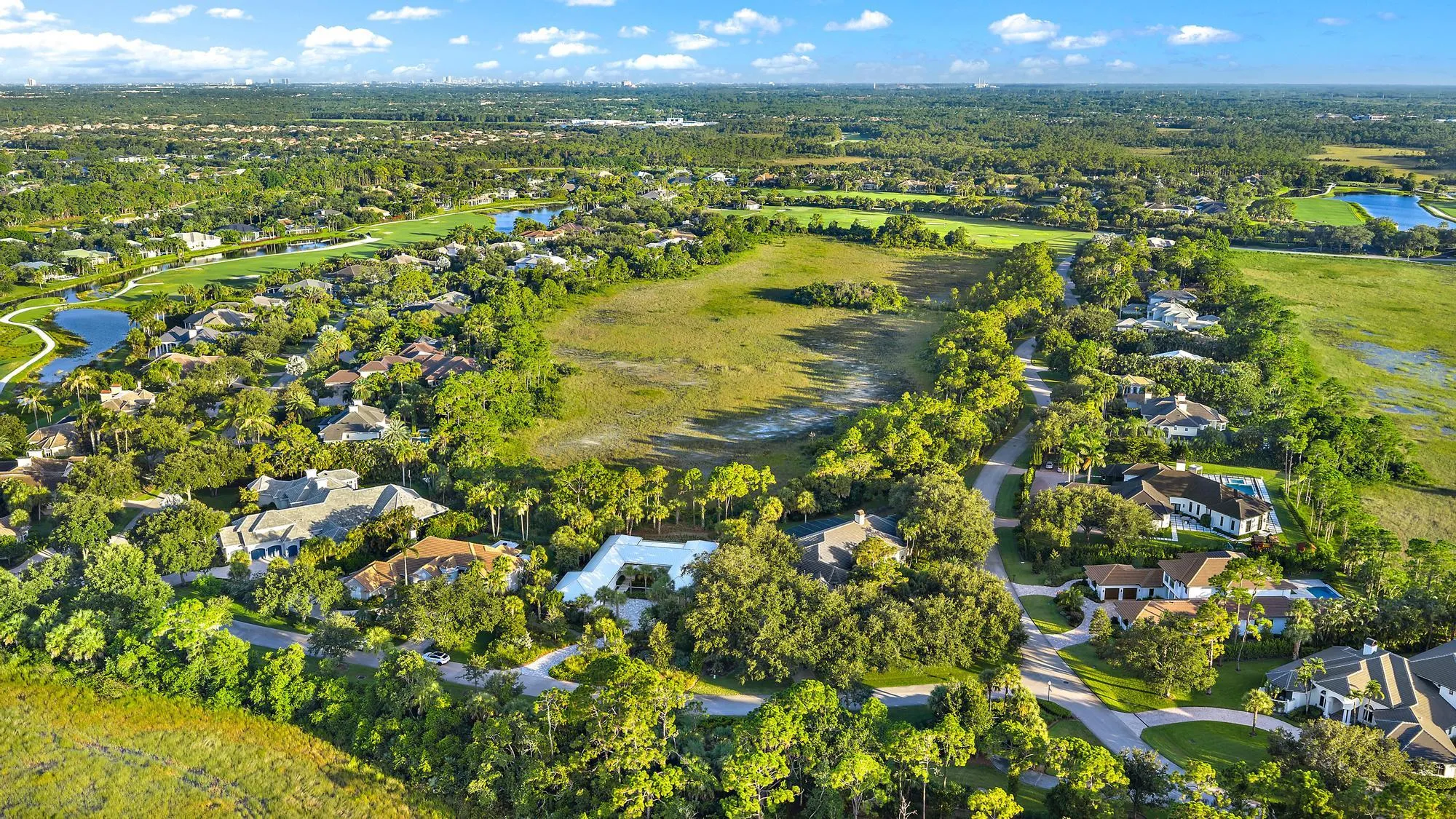 Expansive residential area with numerous single-family homes, surrounding a large open green space