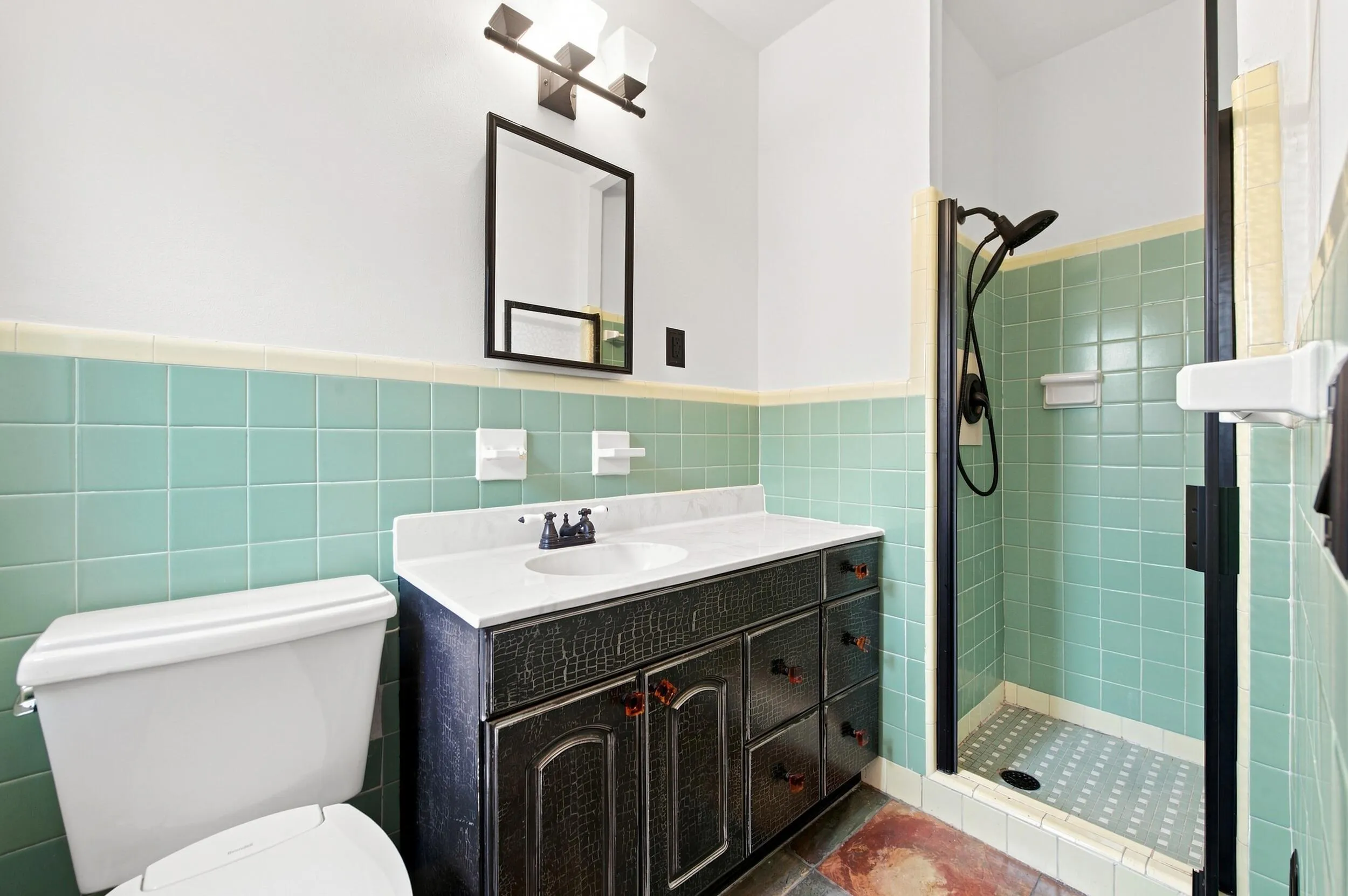 Integrated vanity with a white countertop and basin, matte black faucet, and dark wood-finish cabinetry