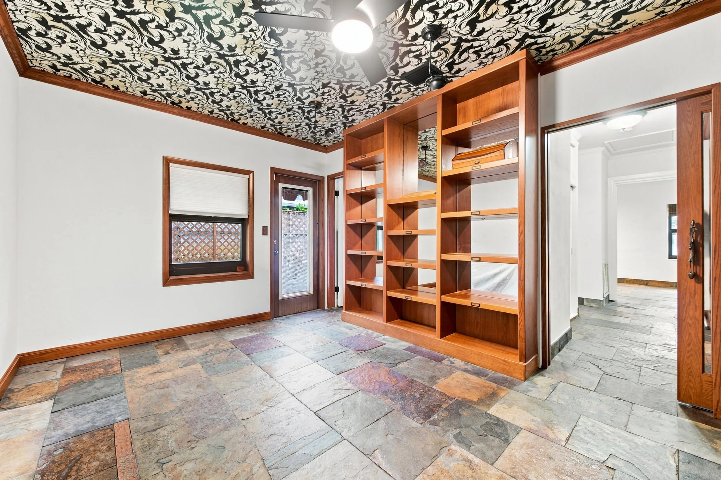 Stone tile flooring complemented by a decorative ceiling and built-in wood shelving