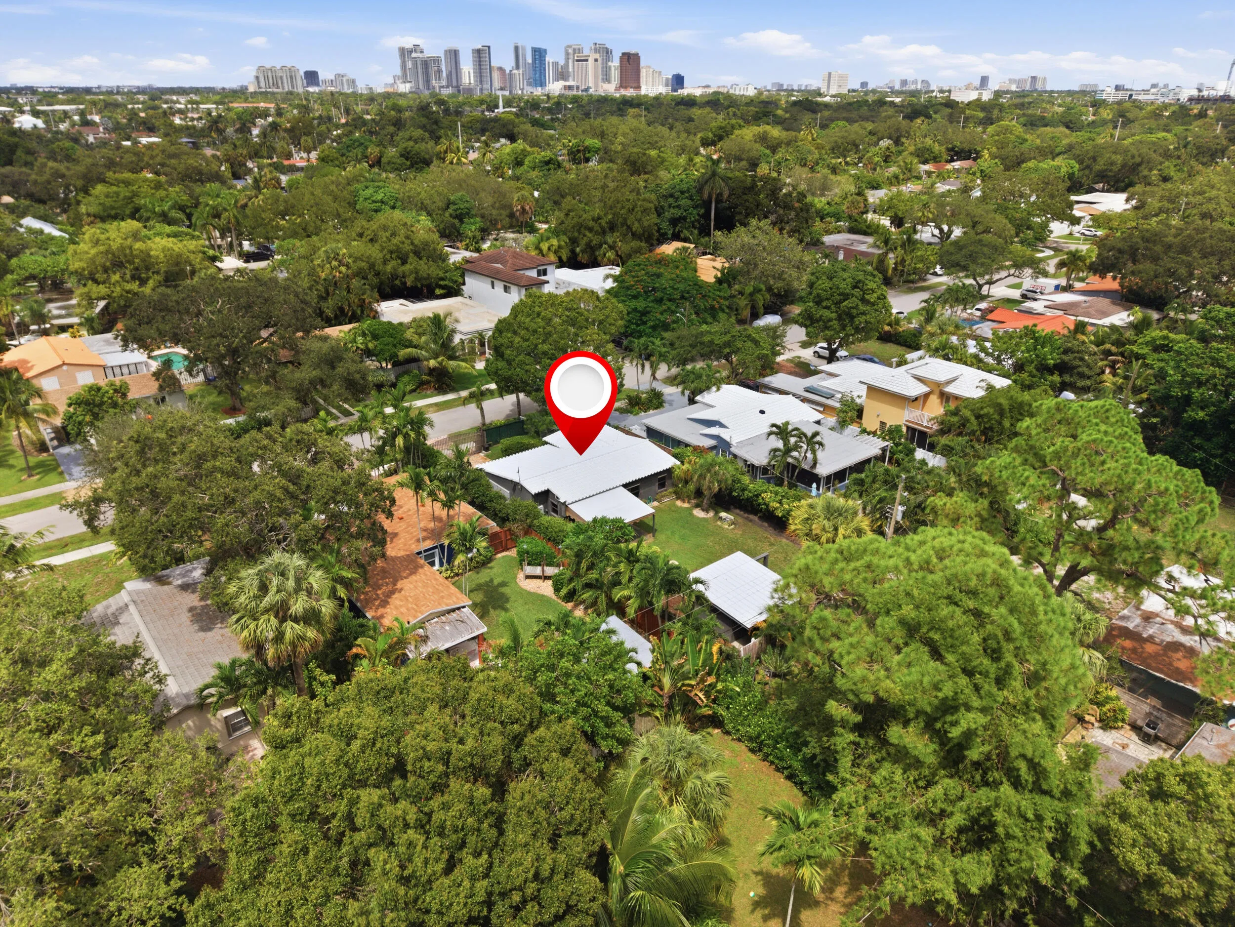 Lush treed surroundings, residential neighborhood setting, distant cityscape backdrop, established properties, bright natural light
