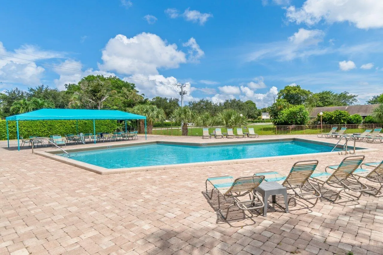 Community pool with lounge seating and a shaded poolside area.