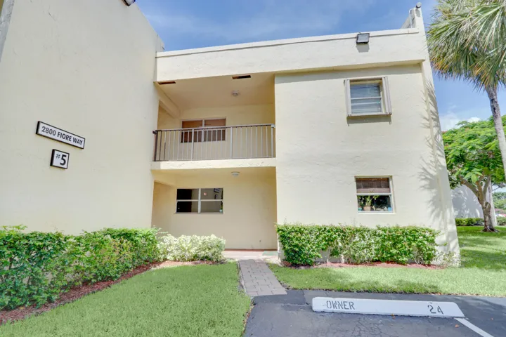 Exterior view of the condominium building and walkway leading to the entrance.
