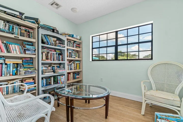 Community library with bookshelves, comfortable seating, and natural light