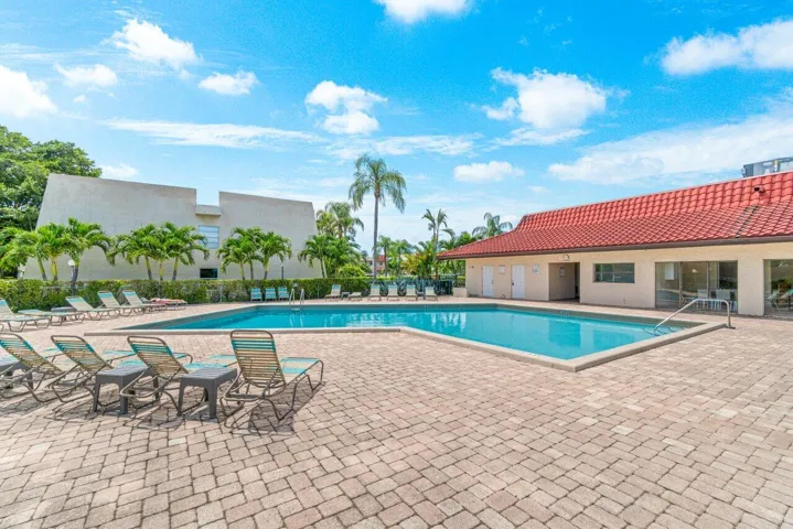 Additional view of the community pool, lounge deck, and clubhouse.