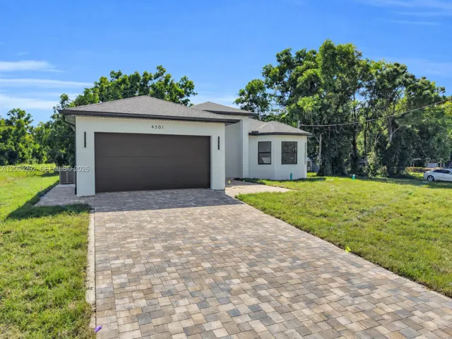 Single-story exterior featuring a paver driveway, an attached two-car garage, and stucco siding under a hipped roof