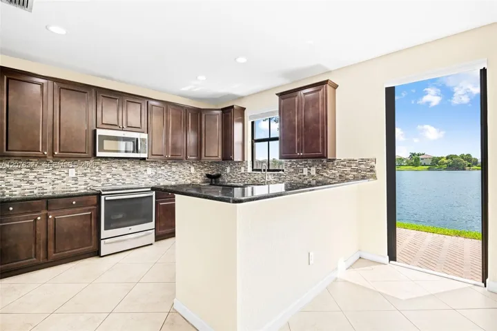 Large kitchen overlooking the backyard with a water view
