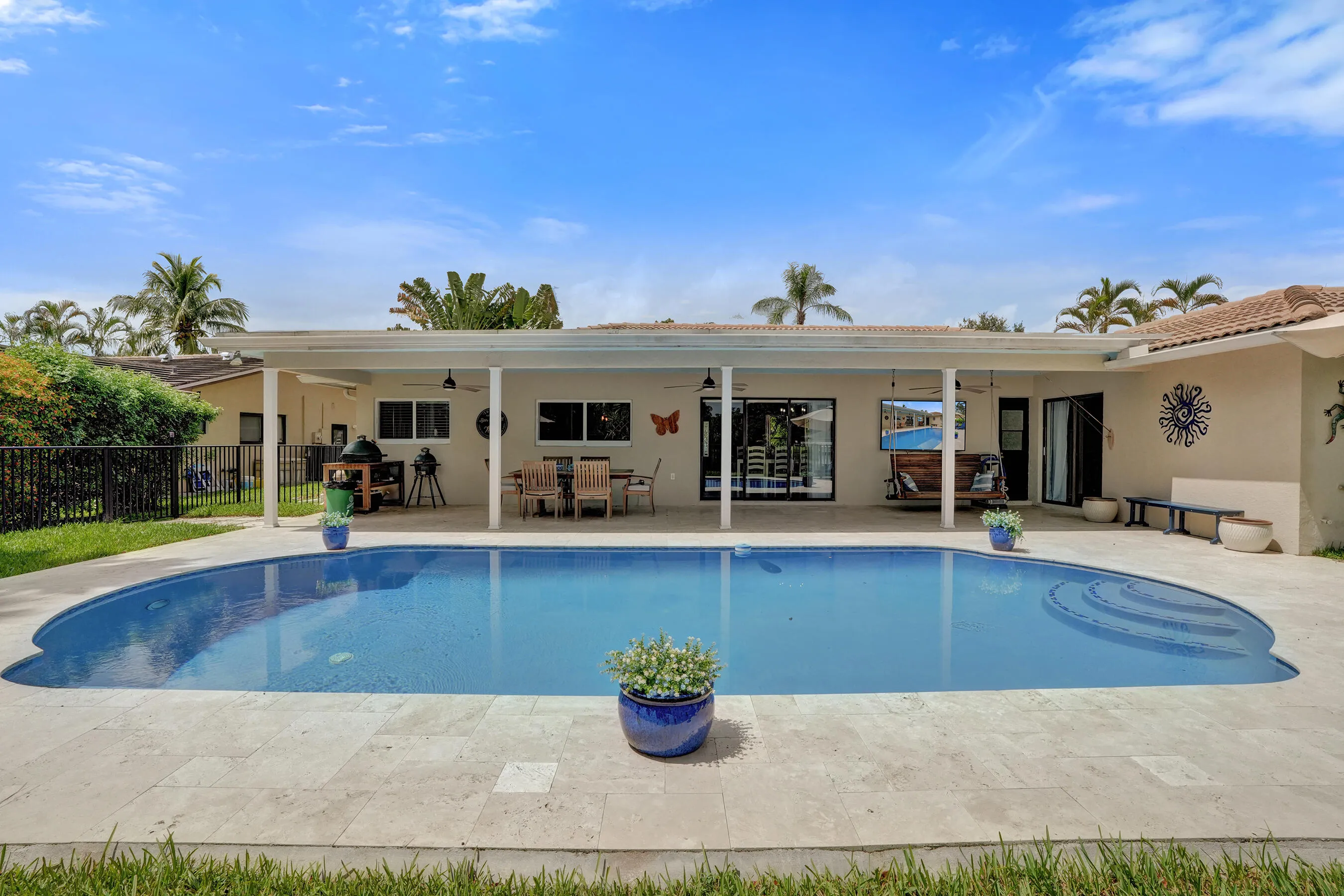 Covered patio offering multiple sitting areas with travertine tile