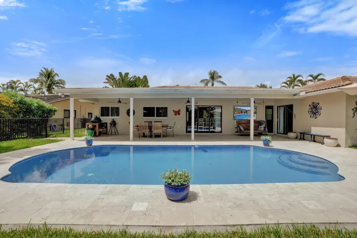 Covered patio offering multiple sitting areas with travertine tile