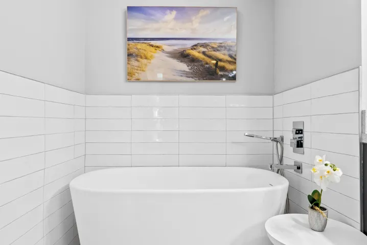 Remodeled primary bathroom with shower, dual sinks & freestanding bathtub