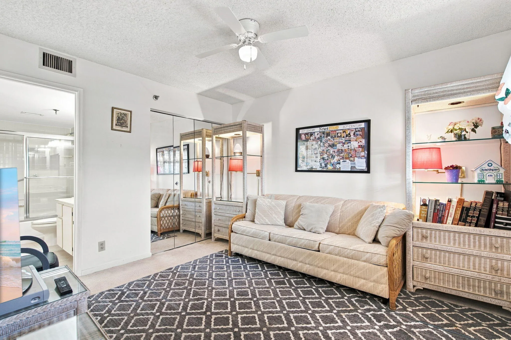 White walls and ceiling fan, with mirrored closet doors and built-in shelving