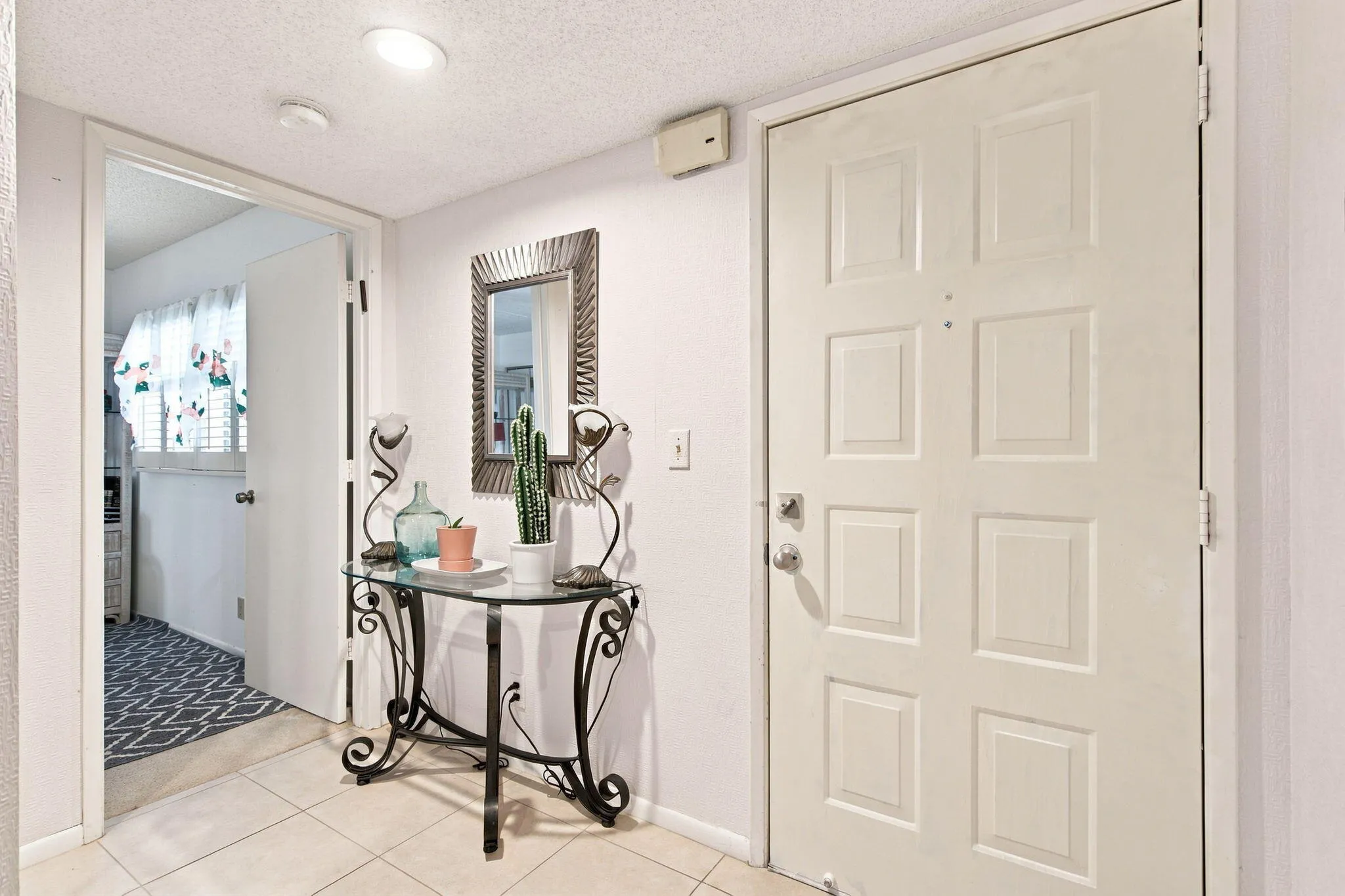 Welcoming foyer featuring tile flooring, recessed lighting, and a decorative console table with ornamental mirror