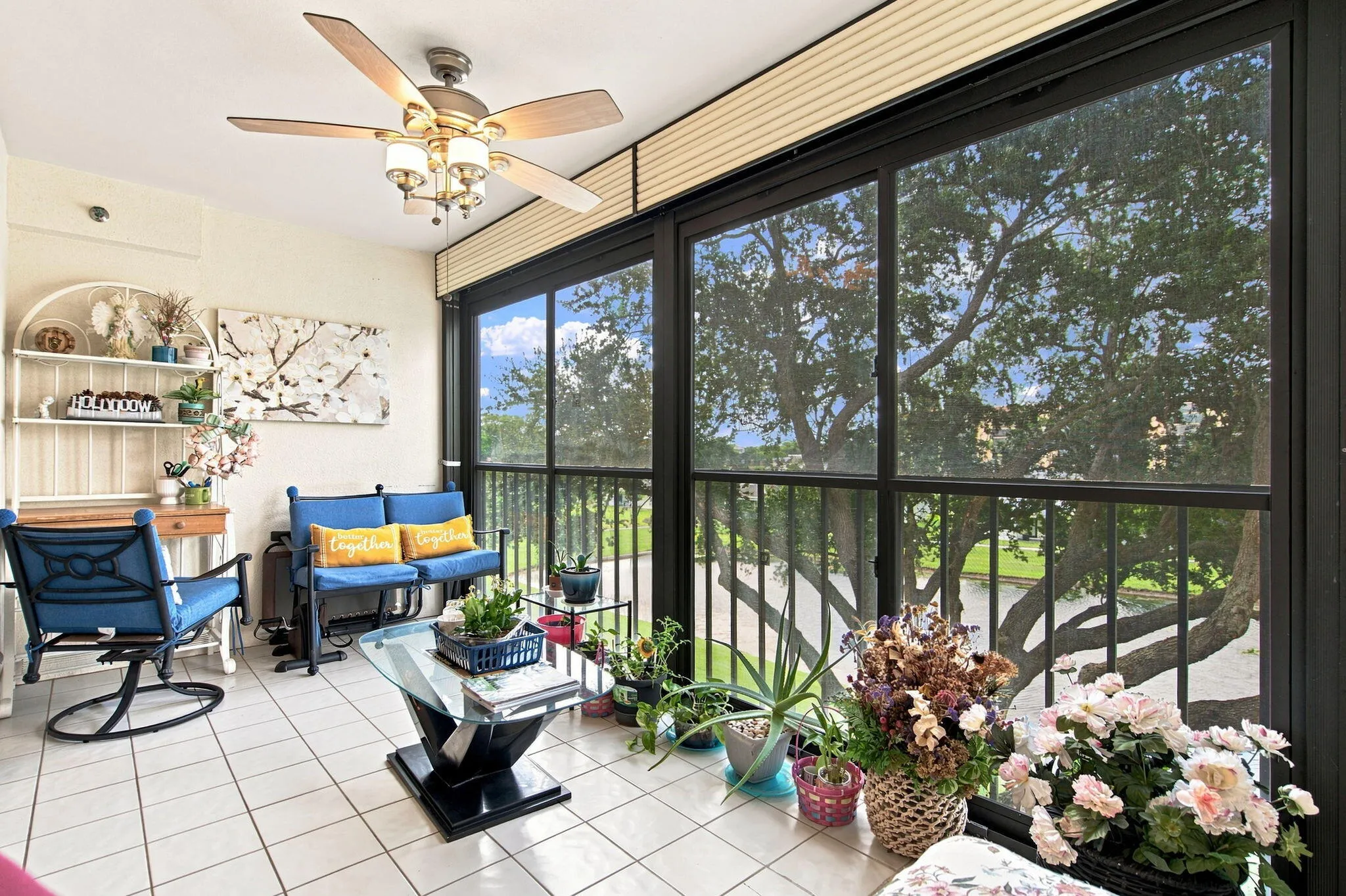 Screened-in patio with tiled flooring, large windows, and a ceiling fan