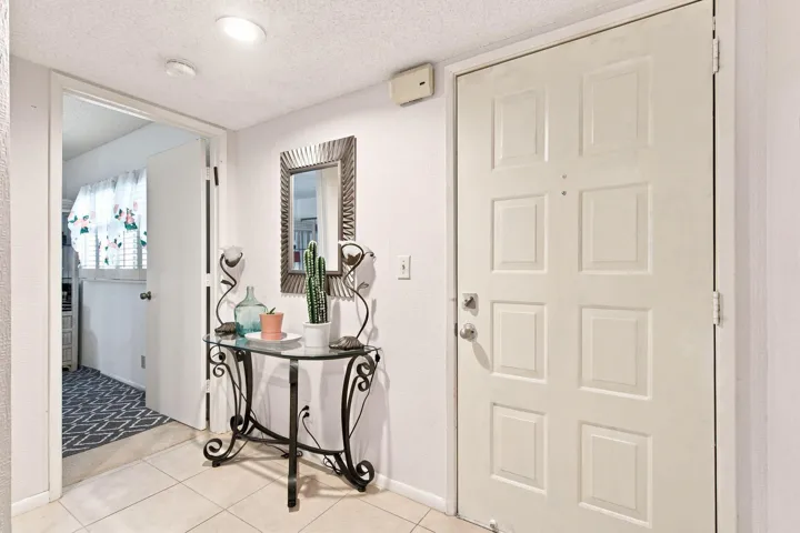 Welcoming foyer featuring tile flooring, recessed lighting, and a decorative console table with ornamental mirror