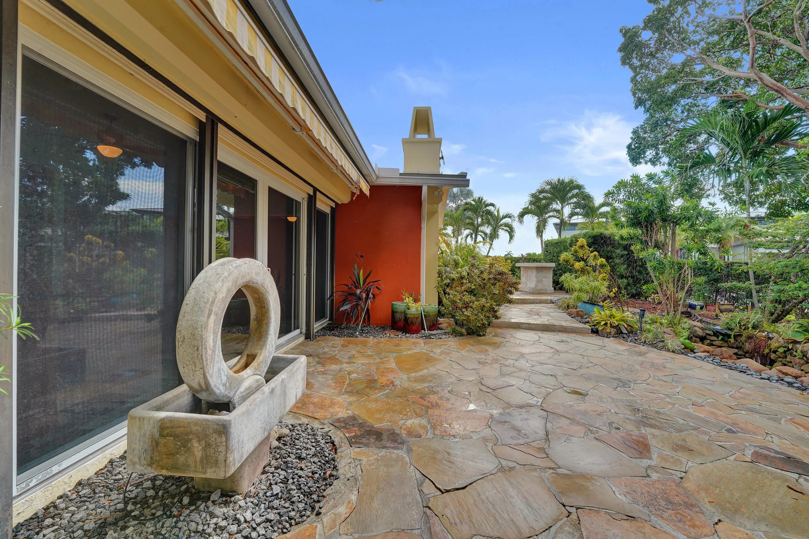 Expansive stone patio with varied flagstone pavers and a decorative water feature