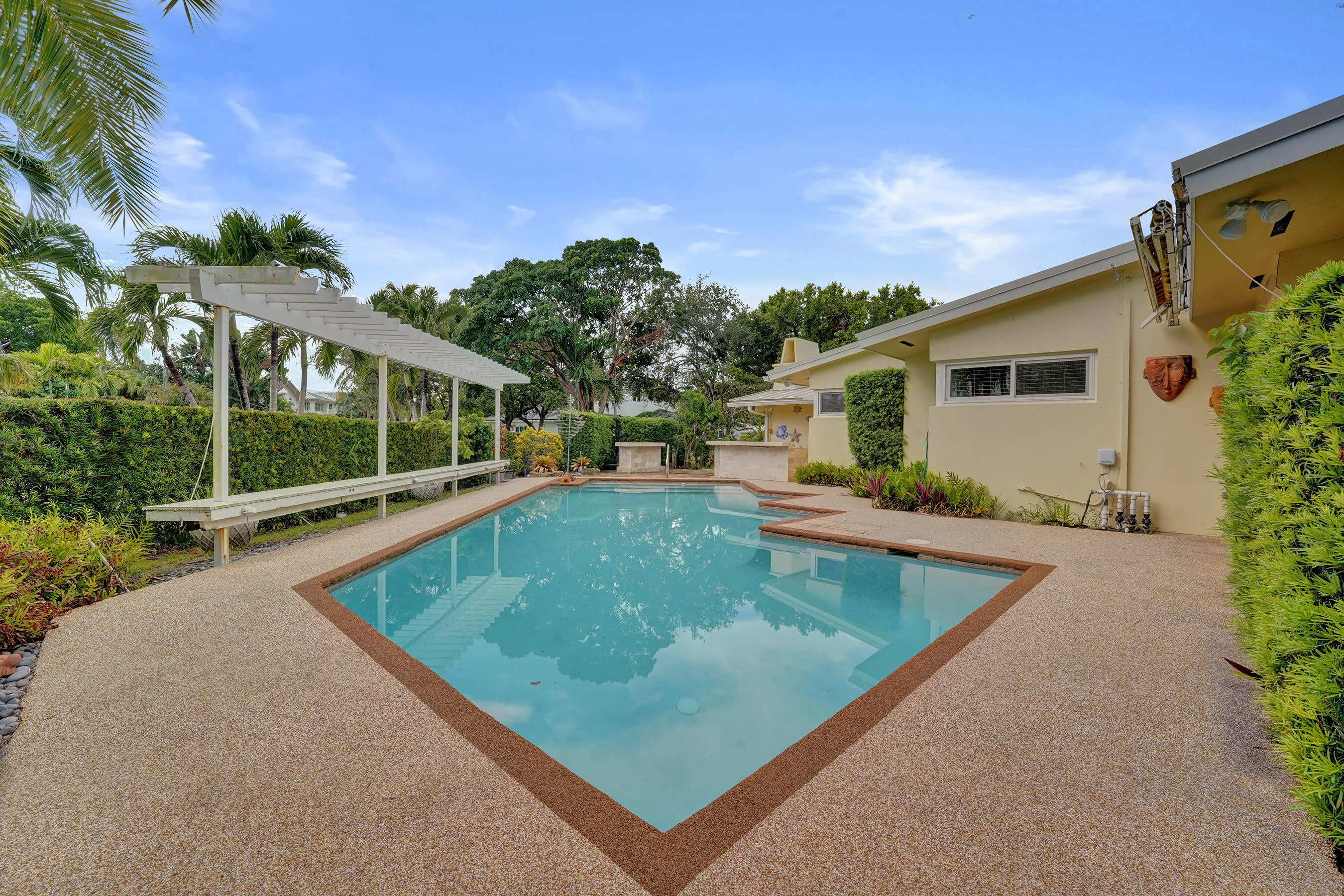 Rectangular pool with an integrated spa, surrounded by aggregate-finish decking