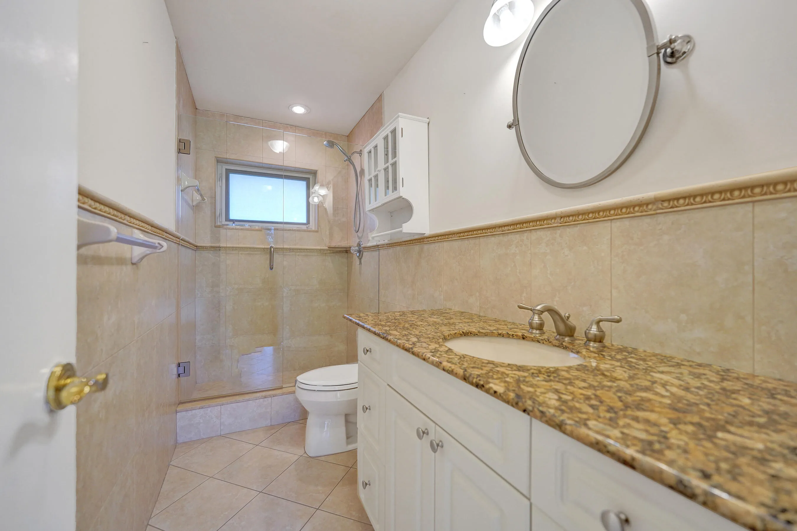 Vanity with stone countertop, integrated sink, and white cabinetry