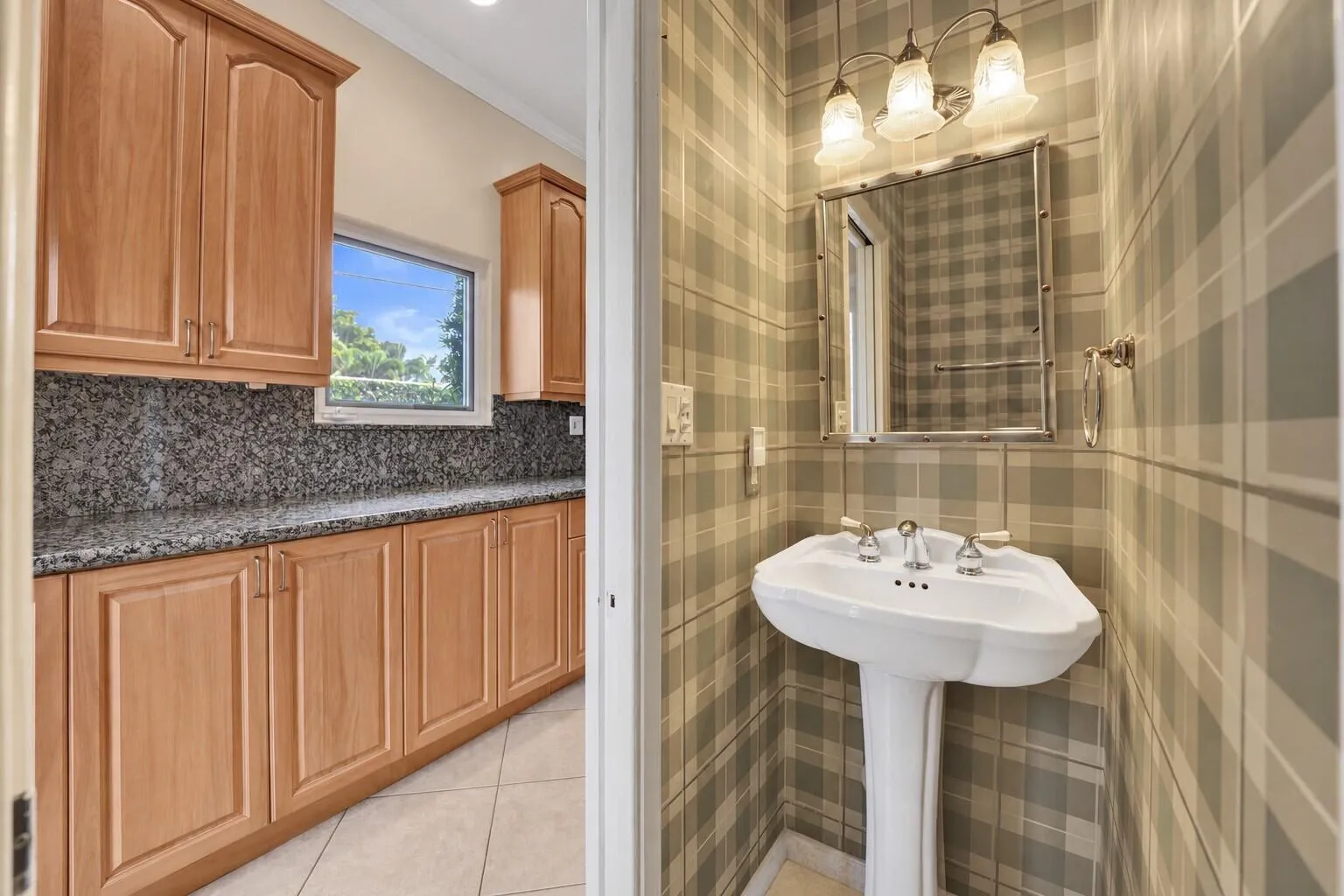 Powder room, guest bath with pedestal sink, polished chrome fixtures, plaid wall covering, and a tri-light vanity fixture.