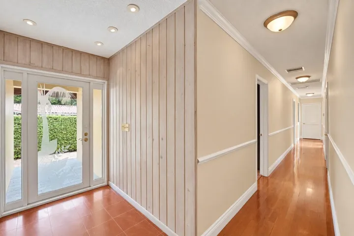 Entryway with recessed lighting, wood plank wall paneling, and a double-door entry with sidelights