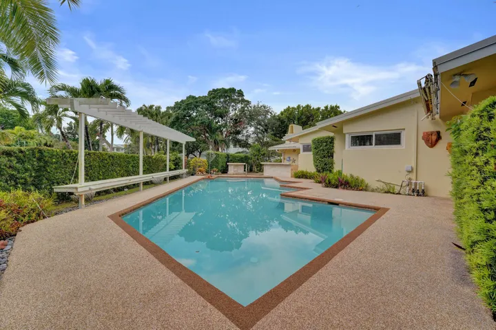 Rectangular pool with an integrated spa, surrounded by aggregate-finish decking