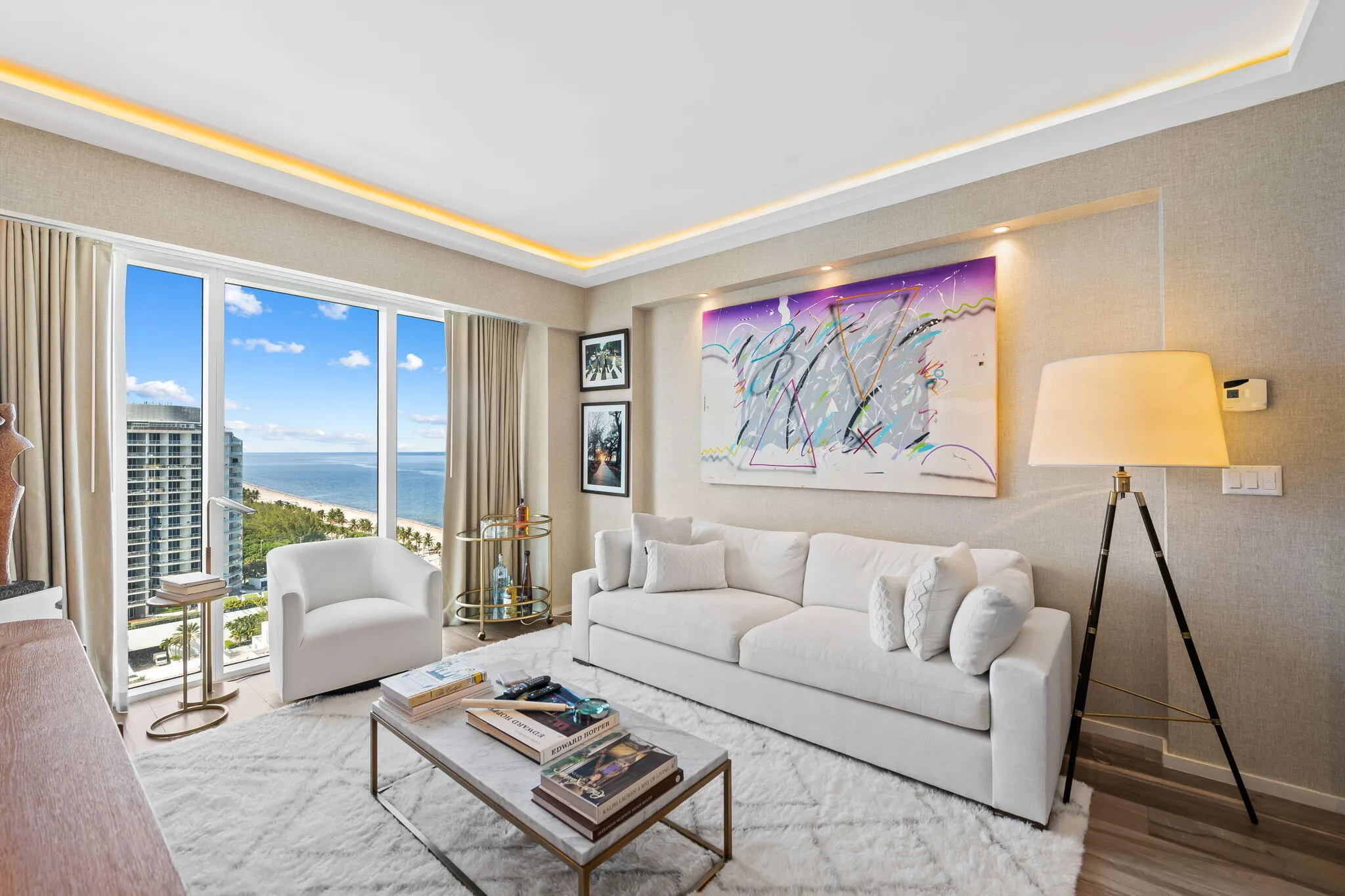 Floor-to-ceiling windows with a prominent ocean and beach backdrop