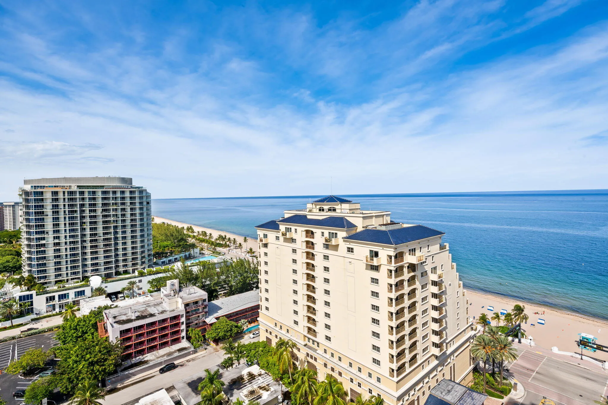 Expansive ocean and coastline scenery, with multiple high-rise buildings featuring balconies