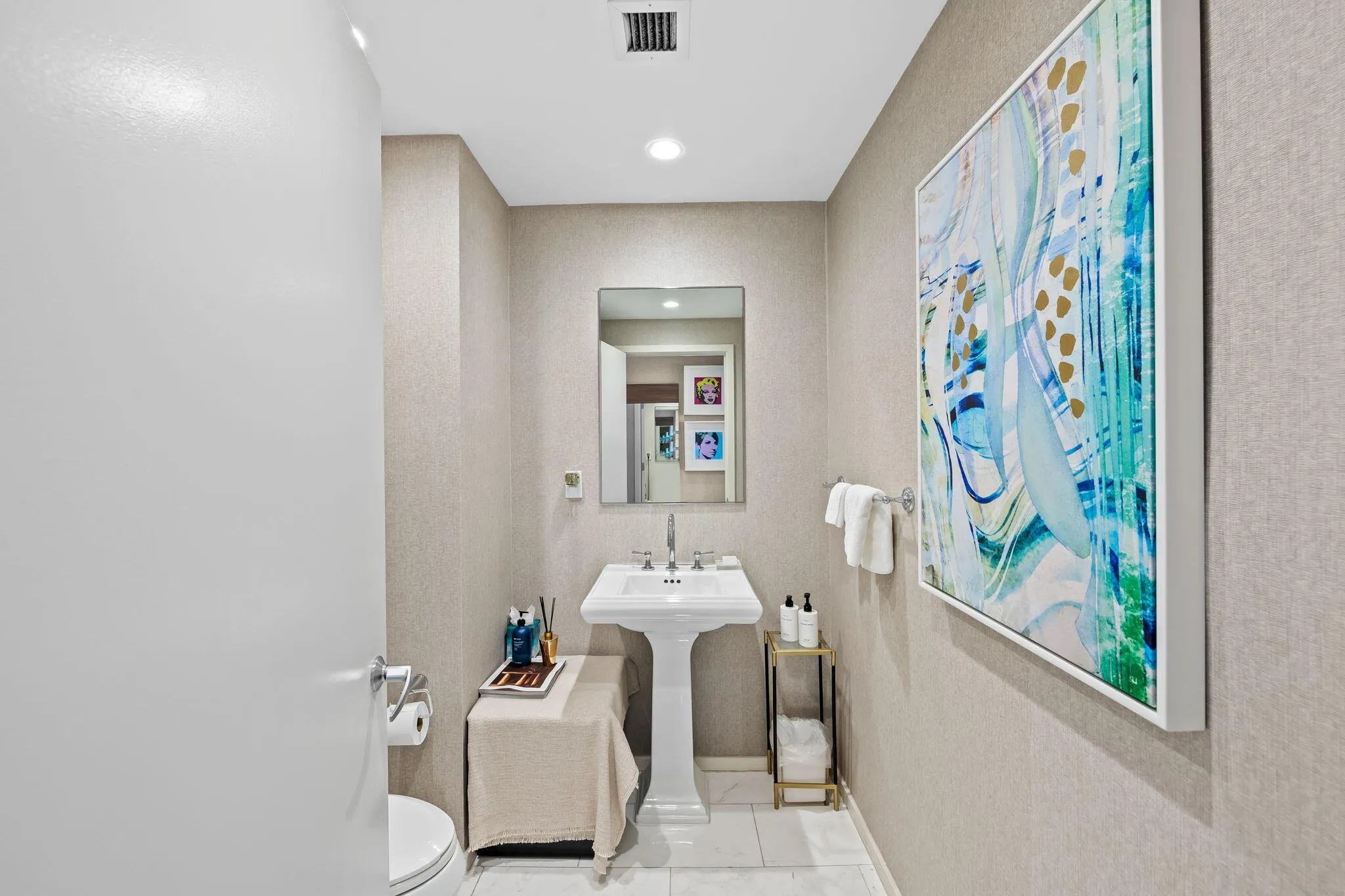 Pedestal sink with polished chrome fixtures, recessed lighting, wall-mounted mirror, and textural wall covering
