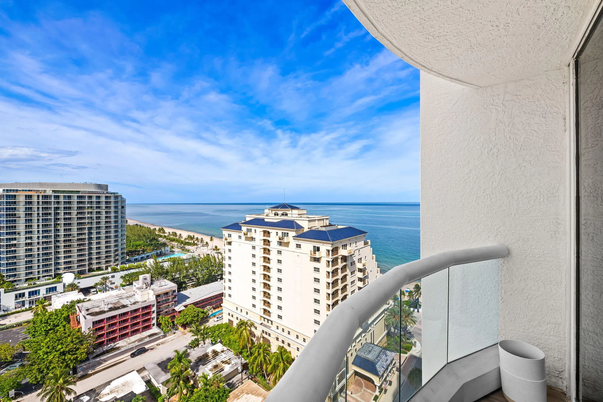 Curved balcony with glass railing, providing panoramic ocean and city views
