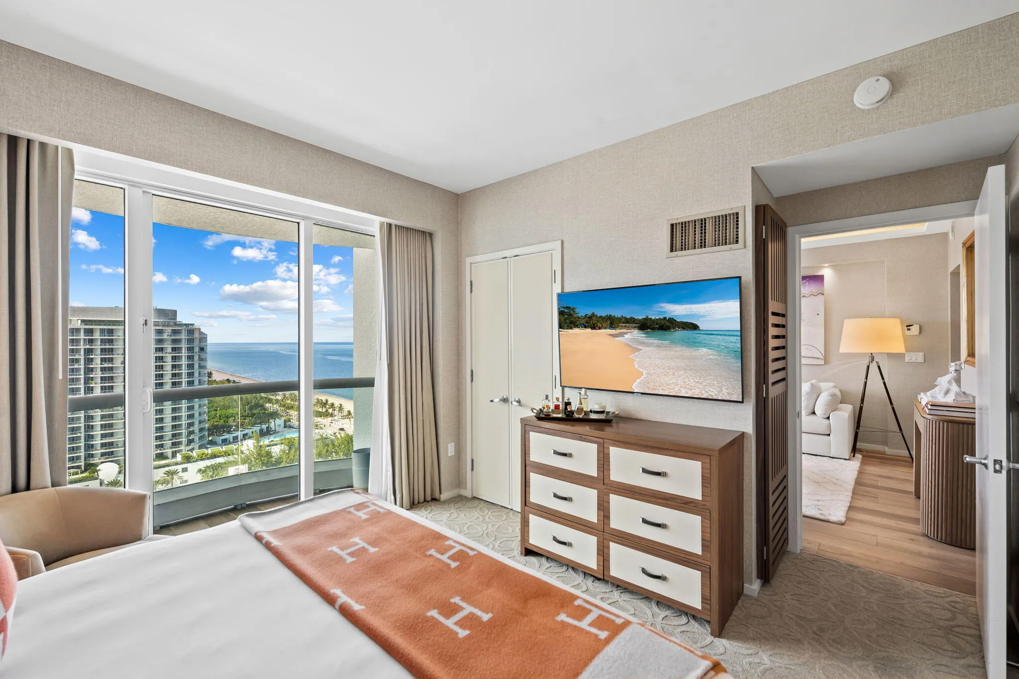 Sliding glass doors opening to a balcony, offering expansive water and cityscape scenery